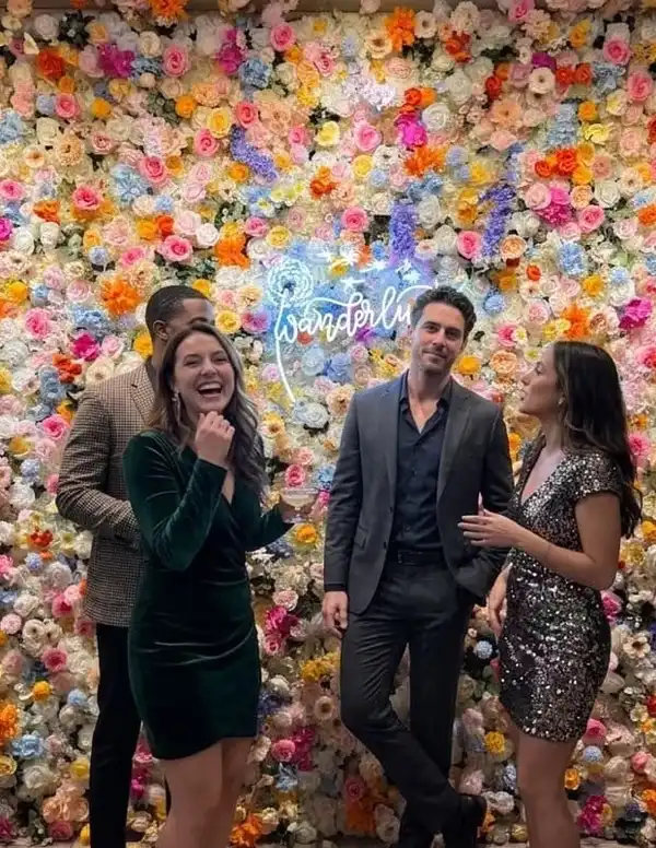 Party guest posing in front of the flower wall photo backdrop at Wanderlust Las Vegas